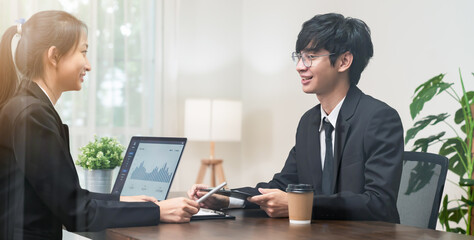 Teamwork Brainstorming Meeting and new startup project in the workplace, Smily Asian businesspeople working on laptop with graph documents.