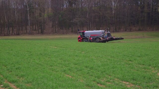 Fertilizer vehicle going over a green field.