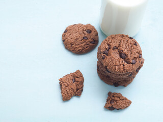 A pile of homemade double chocolate chip cookies on a blue wooden background..