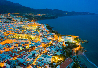 Aerial view of illuminated Nerja city at Mediterranean coast, Costa del Sol, Spain