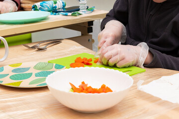 children in a school class at a labor lesson prepare a vegetable salad. parts of hands close-up. selective focus