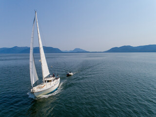 Fototapeta premium USA, Alaska, Tongass National Forest, Aerial view of Gulf 32 sailboat S/V Abuelos sailing through Frederick Sound on summer afternoon