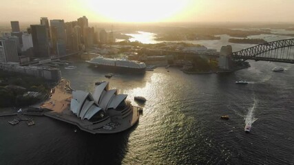 Aerial circling over Sydney Opera house and Harbor Bridge with cityscape in background