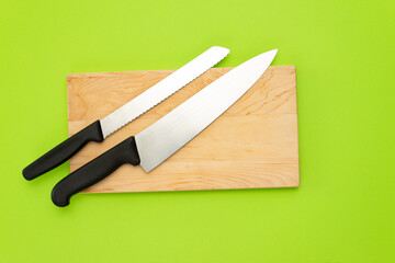 tabla de cocinar y cuchillo de pan y cuchillo chef, sobre fondo verde, comida saludable, utensilios de cocina del hogar, vida saludable, artículos de restaurante