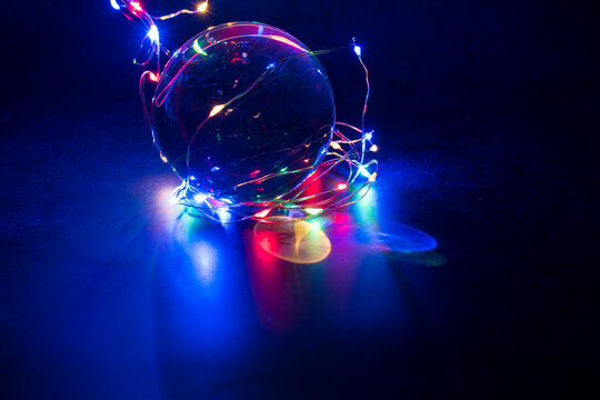 Neon Led color lights reflected in crystal ball with dark background.