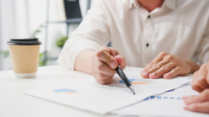 Happy young Asia businessmen and businesswomen meeting brainstorming ideas about new paperwork project colleagues working together planning success strategy enjoy teamwork in small modern office.