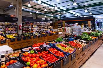 Colorful counter with large assortment of fresh fruits and vegetables for sale in eco products store