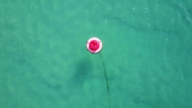 Red Buoy Floating On Crystal Clear Blue Water Of Ocean Near Elliott Heads, Australia. - aerial ascend