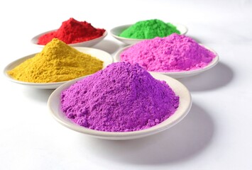Closeup of Indian Holi Festival Colors or Gulal in Plates Isolated on White Background with Selective Focus, Perfect for Wallpaper