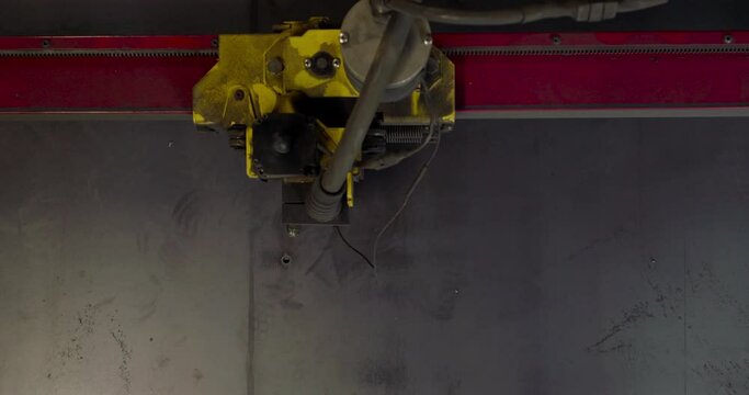 A top down view of a CSC plasma cutter operating and cutting shapes out of steel plate - 4k