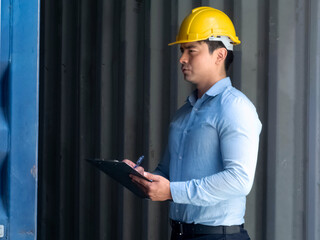 Foreman engineer europe white skin safety yellow hat uniform write look report information warehouse container cargo shipping construction site project.Male manager work import export international.