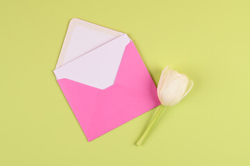 Blank white card with pink paper envelope template mock up. Festive flat lay minimalist style. Holidays and birthday concept.