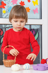 Boy playing with Easter eggs. Festive time. Child development