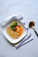 a plate of chicken and vegetable clear soup 