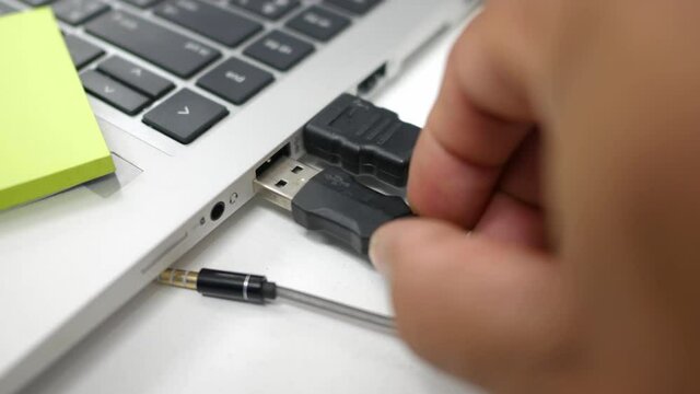 Hand close up of office man to plugging and unplugging the signal cable from the computer