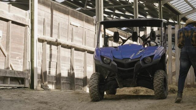 Man walking towards his offroad vehicle in the farm