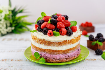 Homemade berry cake decorated with fresh raspberries and blackberries.