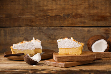 Board with piece of tasty coconut pie on wooden background