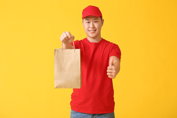 Courier of food delivery service showing thumb-up on color background