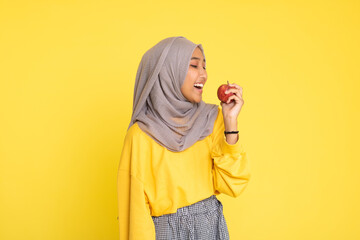 beautiful girl with red apple on yellow background