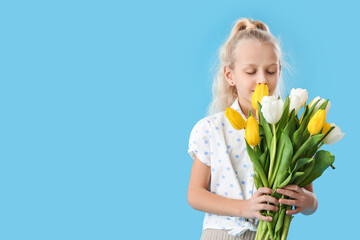 Cute little girl with spring flowers on color background