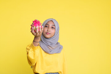 beautiful girl with dragon fruit on yellow background