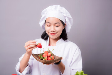 Portrait of a young Asian female chef ready to cook a new dish in the kitchen. Contains Strawberry as an ingredient