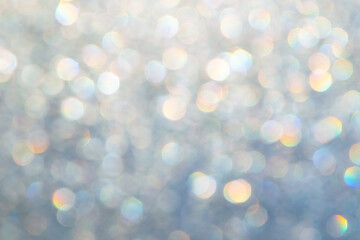 bright glitter background: bokeh effect from many colored lights on frozen glass, toning