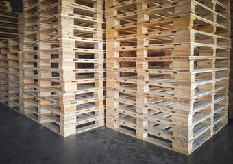 Stacked of wooden pallets rack in storage warehouse.