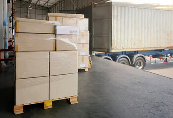 Stack of cardboard on pallet rack. Cargo trailer truck parked loading at dock warehouse. Cargo shipment. Freight truck transportation. Logistics	
