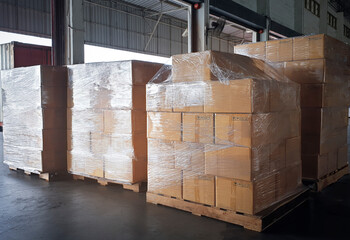 Stacked of cardboard boxes wrapped plastic on pallet rack. Interior of storage warehouse. shipping...