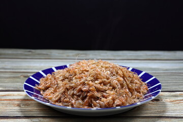 Pile of steamed krill (small shrimp) seasoning with sugar serving on the plate. Famous seafood appetizer menu in Asia restaurant. 