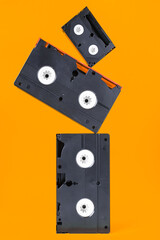 Several cassettes standing on top of each other on a bright orange background. Vintage, retro.