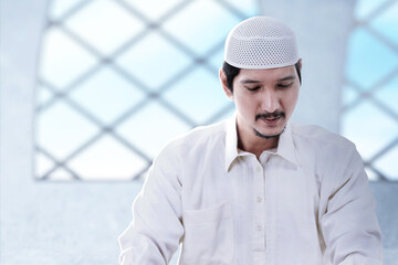 Asian Muslim man sitting