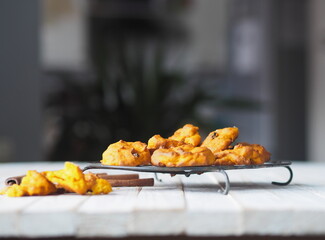 Pumpkin vegetarian cookies with raisins and cinnamon on a wooden background with a pumpkin in the background.