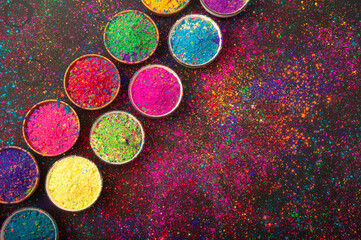 Holi color powder. Organic Gulal colours in bowl for Holi festival, Hindu tradition festive. isolated on black background