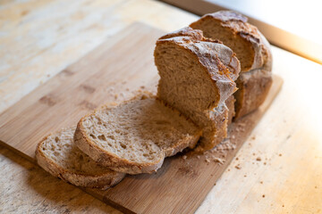 Homemade sliced bread on wooden board and table 