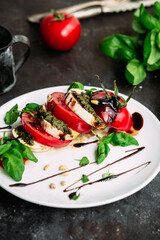 Caprese salad. Tomatoes, mozzarella, basil, pesto, balsamic sauce