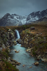 river with waterfall in winter, snow and dry vegetation. famous travel destination - Fairy Pools - Skye Island - Scotland - Uk