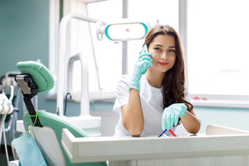 Serious female doctor talking on mobile phone at his desk. Doctor talking on mobile phone