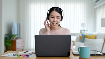 Young attractive business asian woman talking about sale report in video call conference on notebook computer online meeting in working from home, Working remotely and Social isolation concept.