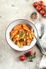 Penne pasta with tomato sause in plate on stone background table. Top view. Italian food