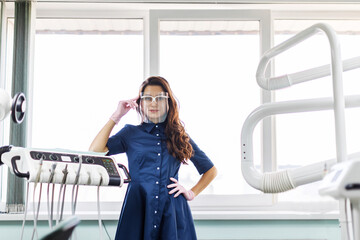 A young female dentist in uniform spends time in the dentist's office