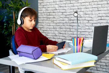 Boy playing on the mobile phone during online classes