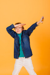 Fototapeta premium The little boy phones on the yellow background