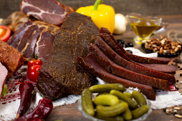 Assortment of cold cuts, a variety of processed cold meat products. On a wooden background