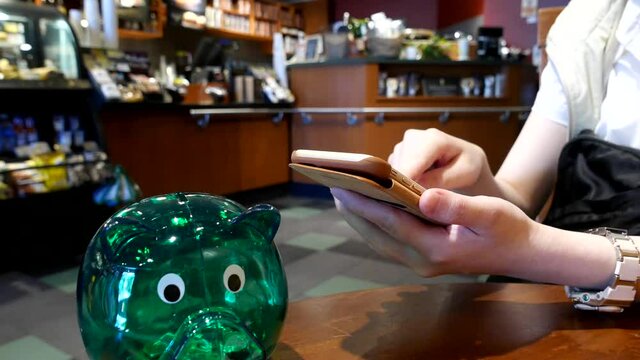 Hand browsing website on iPhone inside Starbucks store with 4k resolution.
