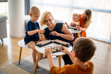 Children and woman learn while playing a board game. Education, fun, children concept