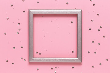 Silver frame layout with space for text and confetti on a pink background. Flat lay, top view