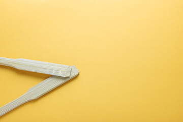 Spatula and Green tropical leaves put on a yellow background with copy space. Minimal summer background concept. Flat lay.